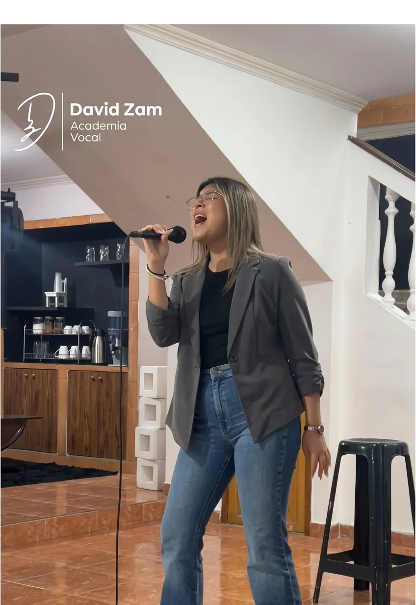 Alumna cantando con un micrófono en una actividad de la academia